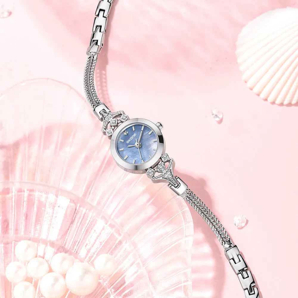 Women's quartz watch with gold white face and slim 8mm profile.