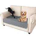 Reversible waterproof dog sofa cushion in dark grey and light grey, shown on a sofa.