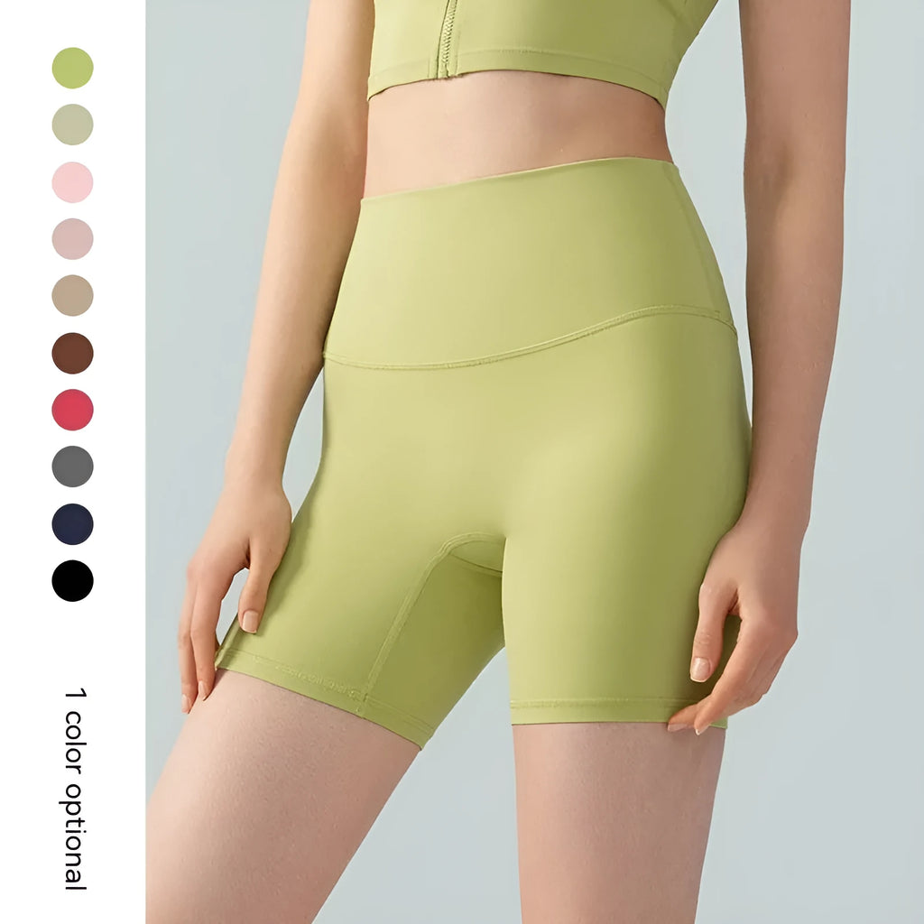 Woman wearing high-waisted leaf green Lycra yoga shorts with a four-point anti-exposure design.