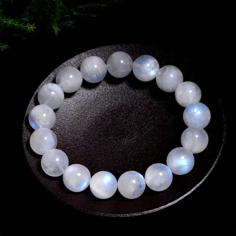 Polished natural blue moonlight moonstone round bead bracelet on white background, showing geometric facets.