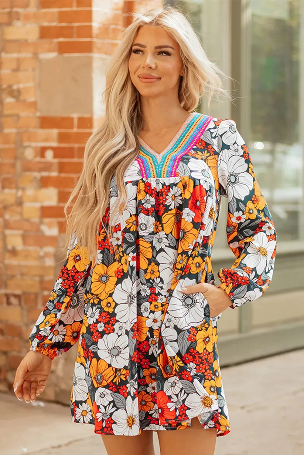 Orange floral print mini dress with striped lace on the V neckline and long sleeves.