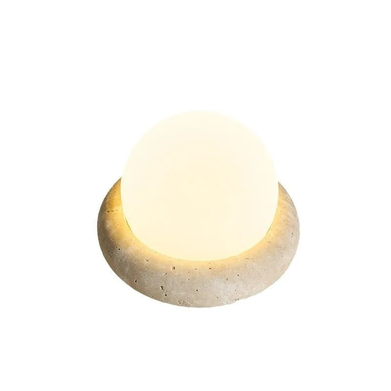 Cream coloured remote control bedside night lamp with yellow cave stone light on wooden table
