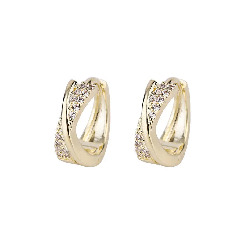 A pair of 14K yellow geometric shaped stud earrings on a plain background.