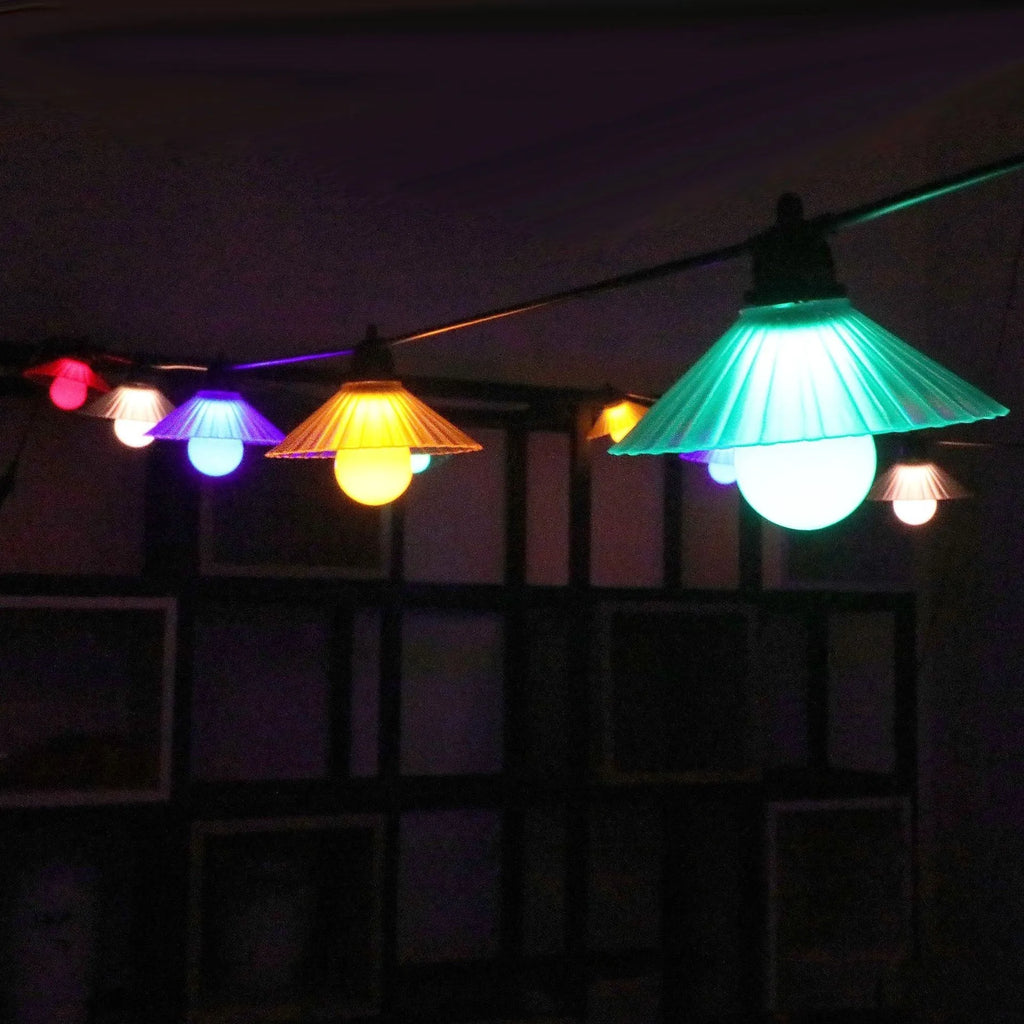 Outdoor LED string lights with flower-shaped globes, showing IP65 waterproof rating and 5V low voltage operation.