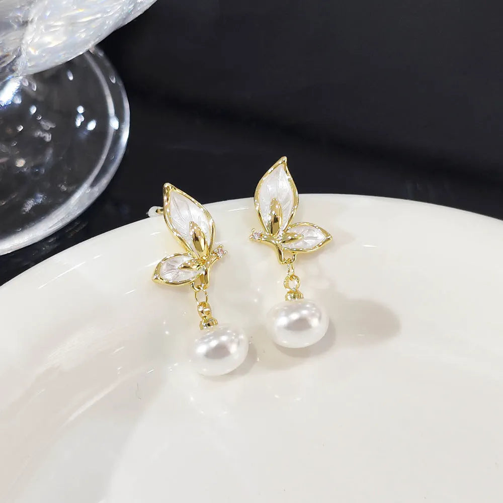 A pair of simple butterfly drop earrings for women with an electroplated finish on a copper base.