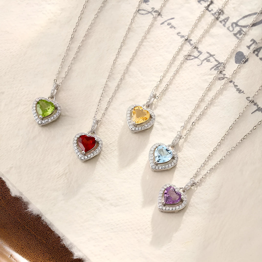 Women's sterling silver heart pendant necklace with natural gemstone on a cross chain.
