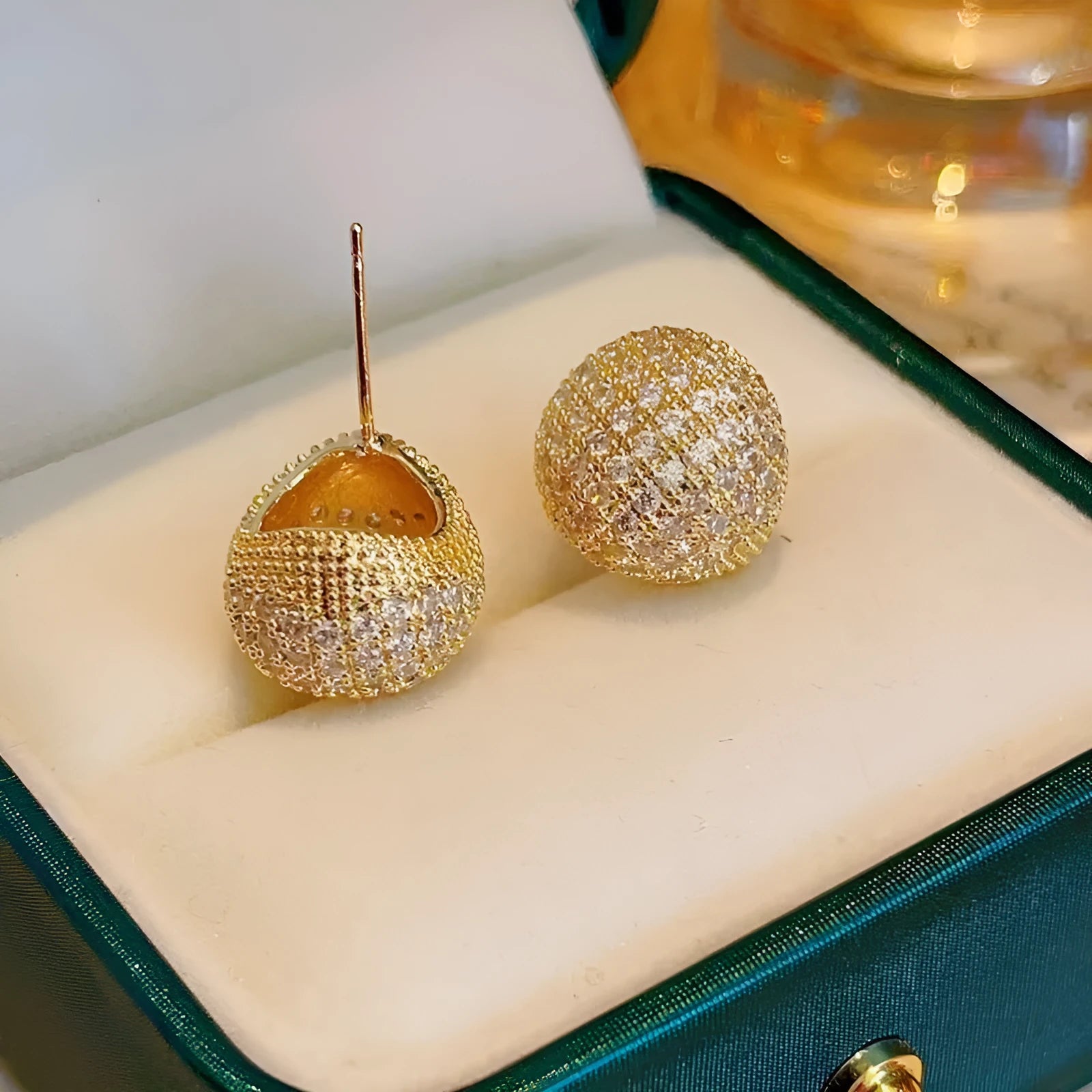 Gold or white geometric drop-shaped clip earrings with spherical bead elements