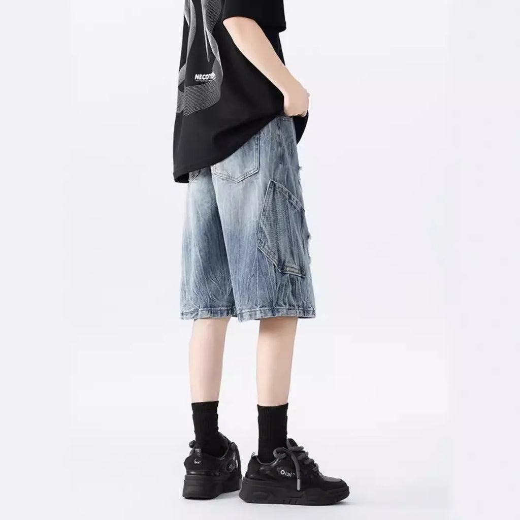 Women's distressed denim shorts with ripped detailing and washed vintage finish in loose retro fit