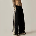 Man wearing black high-waist wide-leg climbing trousers in a casual setting