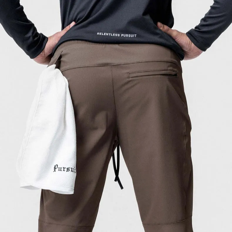 Men's ankle-tied loose fit running pants in a quick-dry fabric, shown in olive green colour.