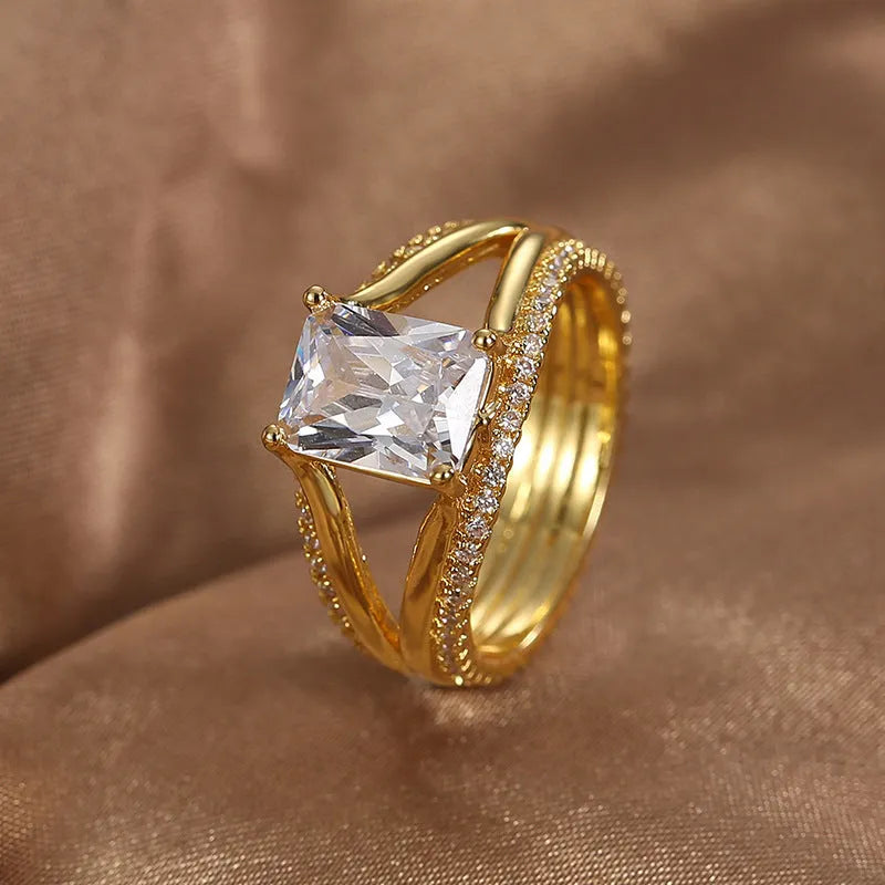 Geometric gold electroplated copper ring for women with a square zircon, shown in sizes 6 to 9.