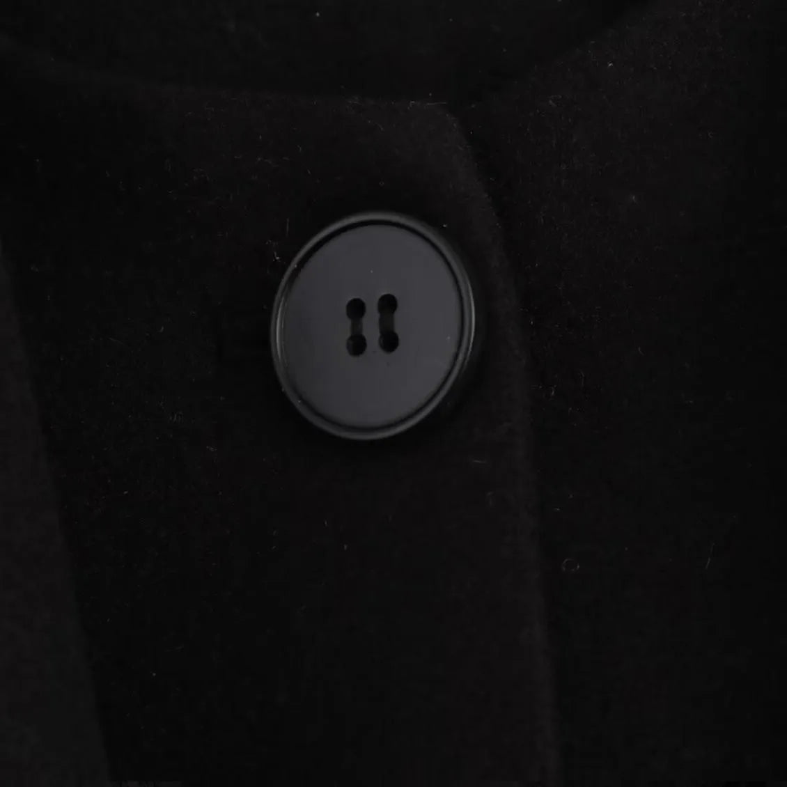 Women's long black overcoat with an artificial fur collar, shown with side pockets.