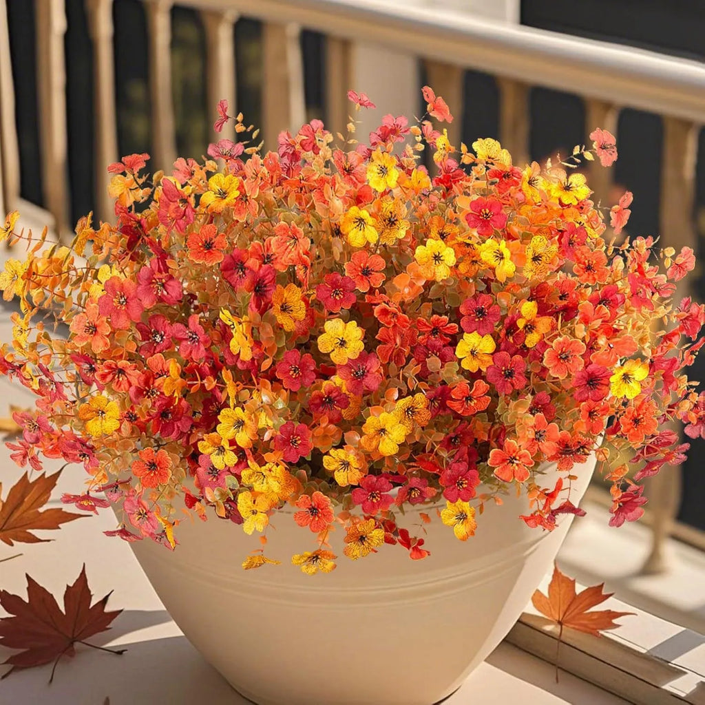 Artificial flower bouquet in autumn colours including orange, yellow, and red tones