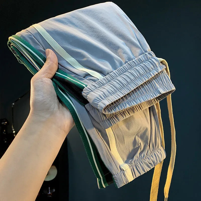 Man wearing solid black ice silk cotton harem pants with a mid waist and full trouser length.