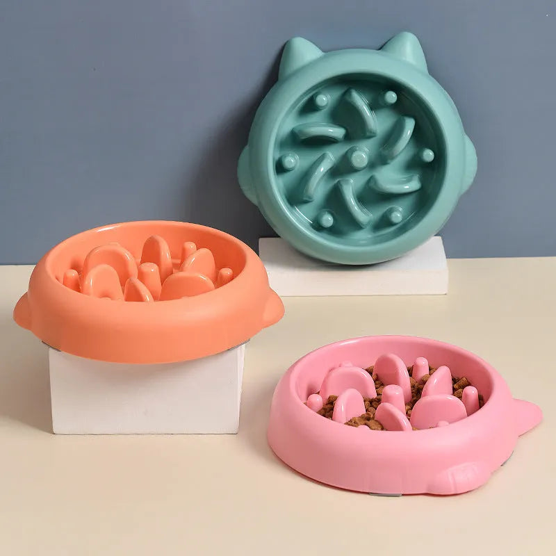 Green bone-ridge slow feeder bowl for dogs and cats on a floor.