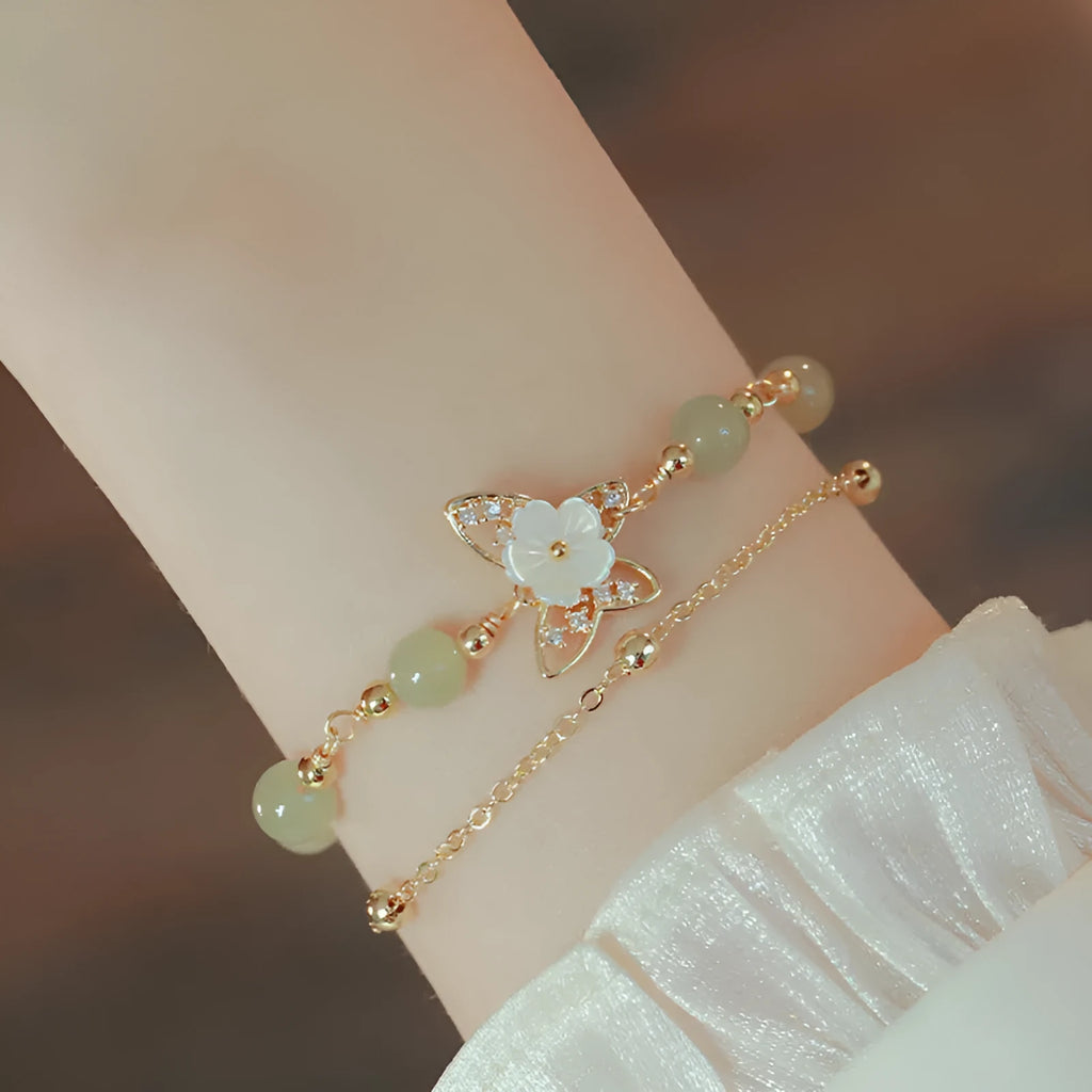 Electroplated copper butterfly bracelet with geometric design and yellow gold finish, showing floral shell motif
