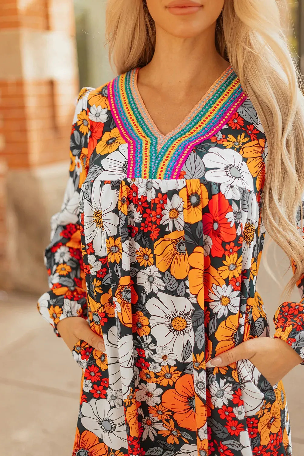 Orange floral print mini dress with striped lace on the V neckline and long sleeves.