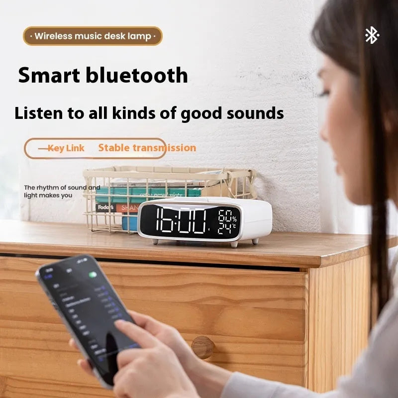 White wireless charging Bluetooth speaker alarm clock with night light on bedside table