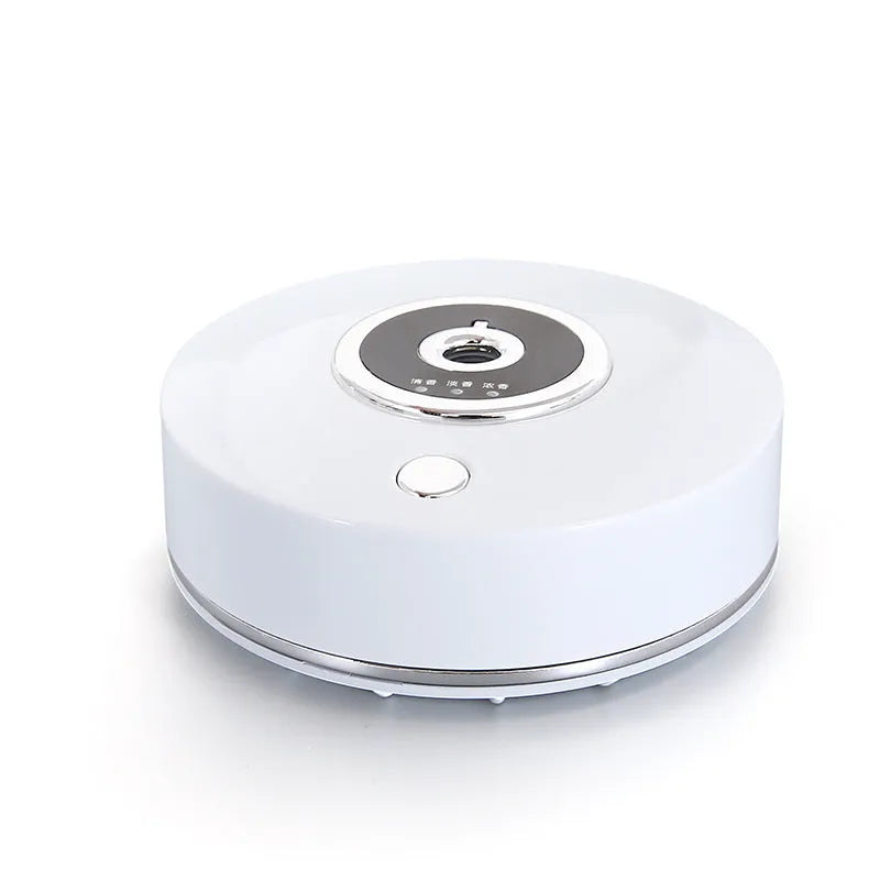 White plastic USB car air freshener diffuser with charging cable and anti-slip pad on a car dashboard.