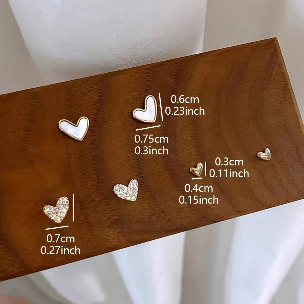 Three pairs of women's heart-shaped alloy earrings in electroplated gold, black, black-white, or pink colours