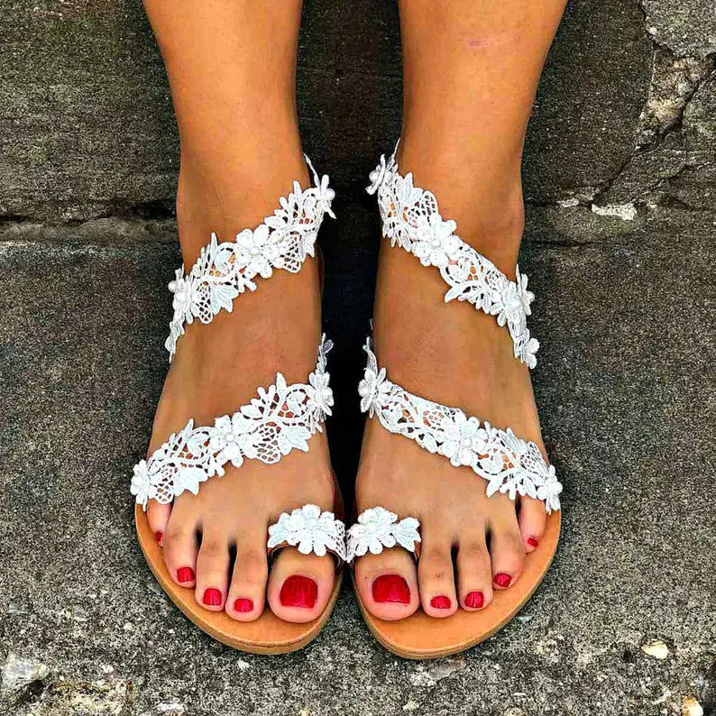 White women's flat sandals with rhinestone and flower decoration on the PU upper.