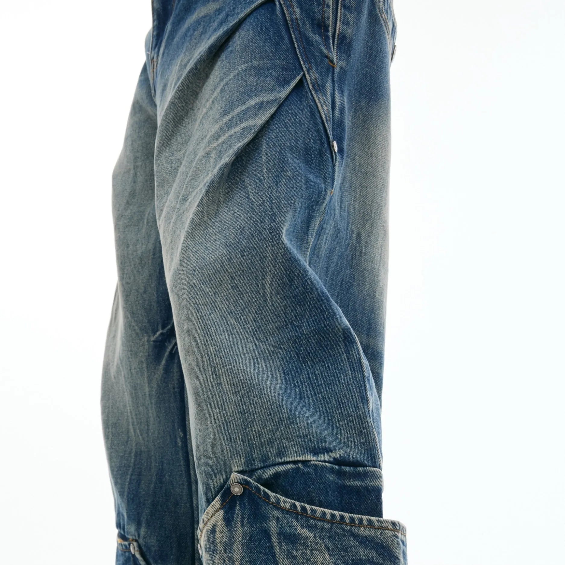 Men's verdant blue loose fit jeans with a retro washed burst pattern and curved knife design details.