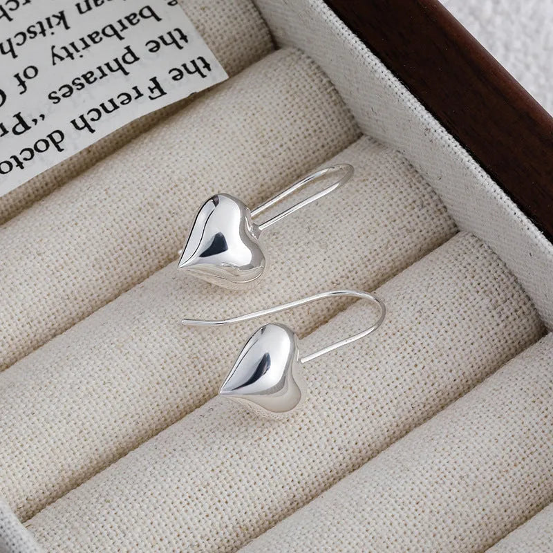 Silver heart shaped earrings with glossy three-dimensional Korean style design