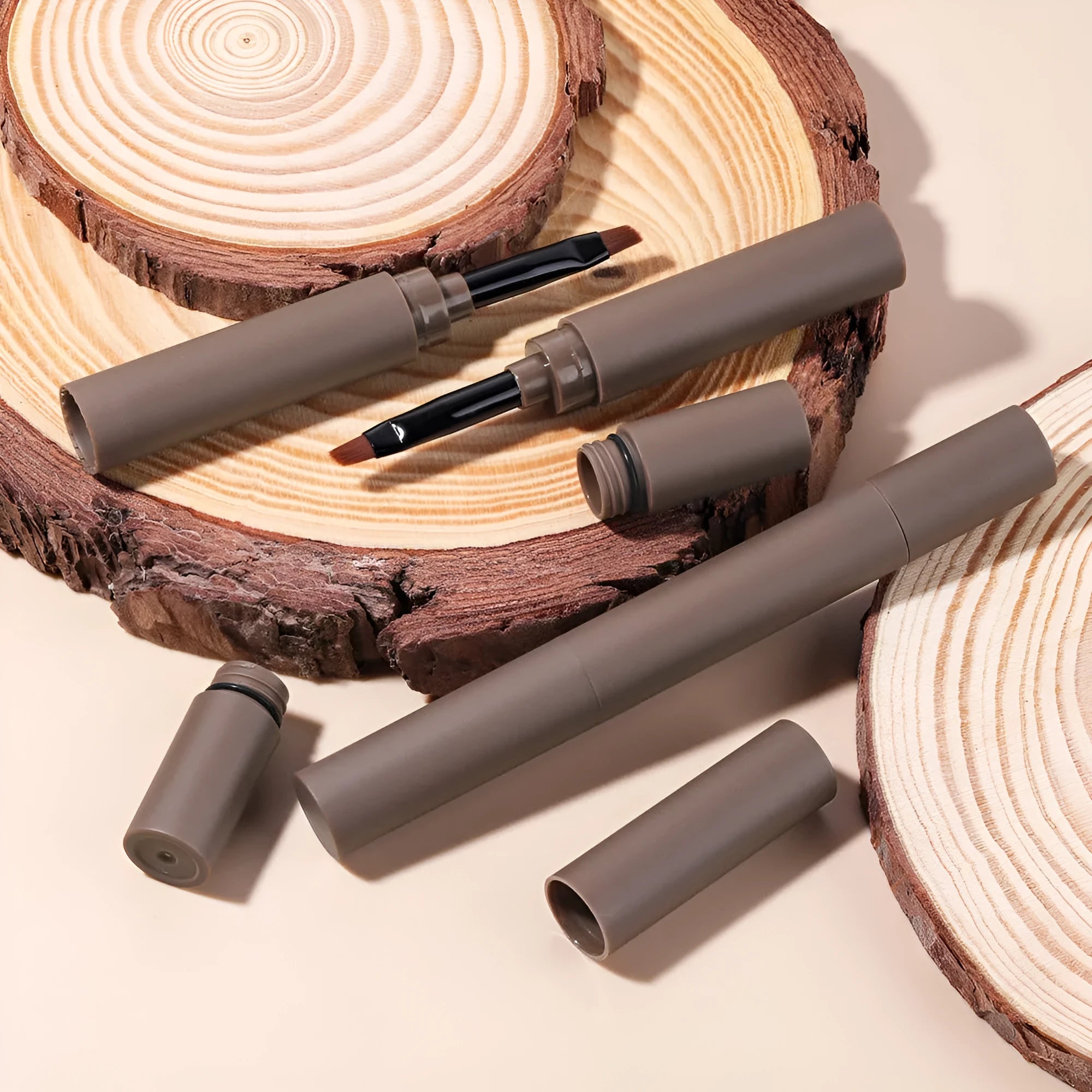 Double-headed eyebrow cream in a tube showing creamy brow product and blending tool, with five neutral shade options displayed.
