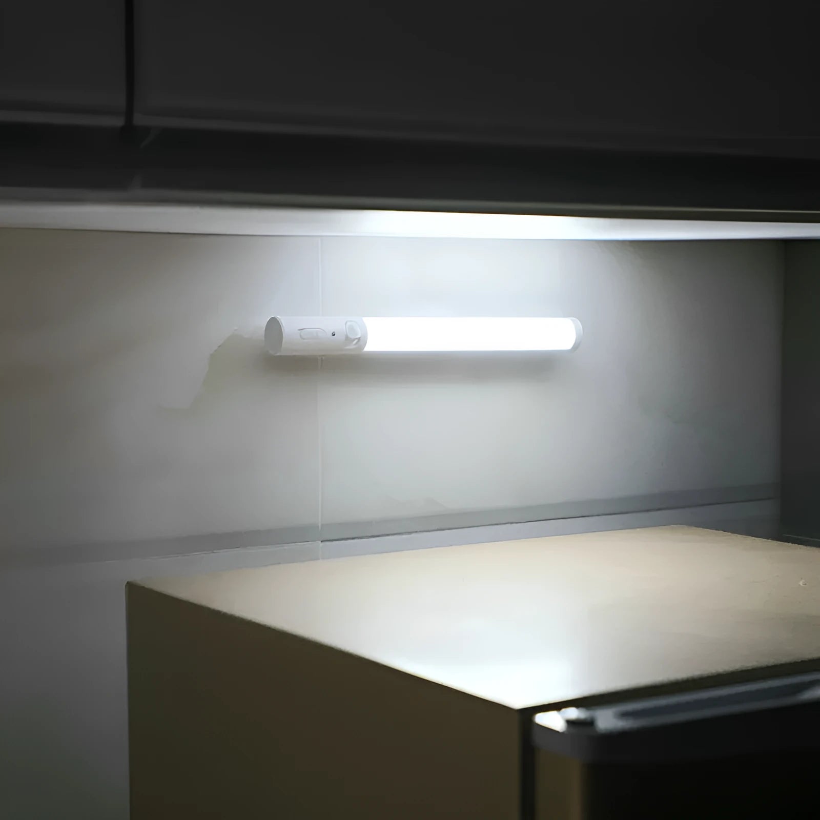 Slim white human body induction LED wall light with magnet back for under-cabinet or wardrobe installation.