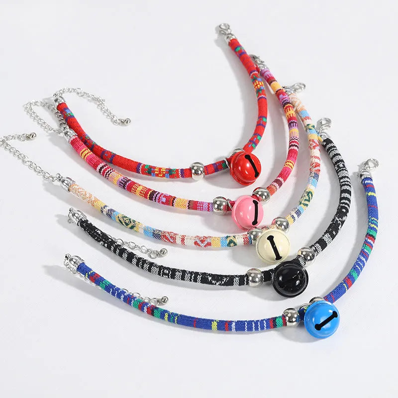 Coloured ethnic style adjustable pet collar with a bell for cats and dogs in black, blue, pink, red, and white.
