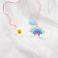 Handmade crocheted wool car pendant shaped like a cartoon avocado with a rainbow flower decoration.