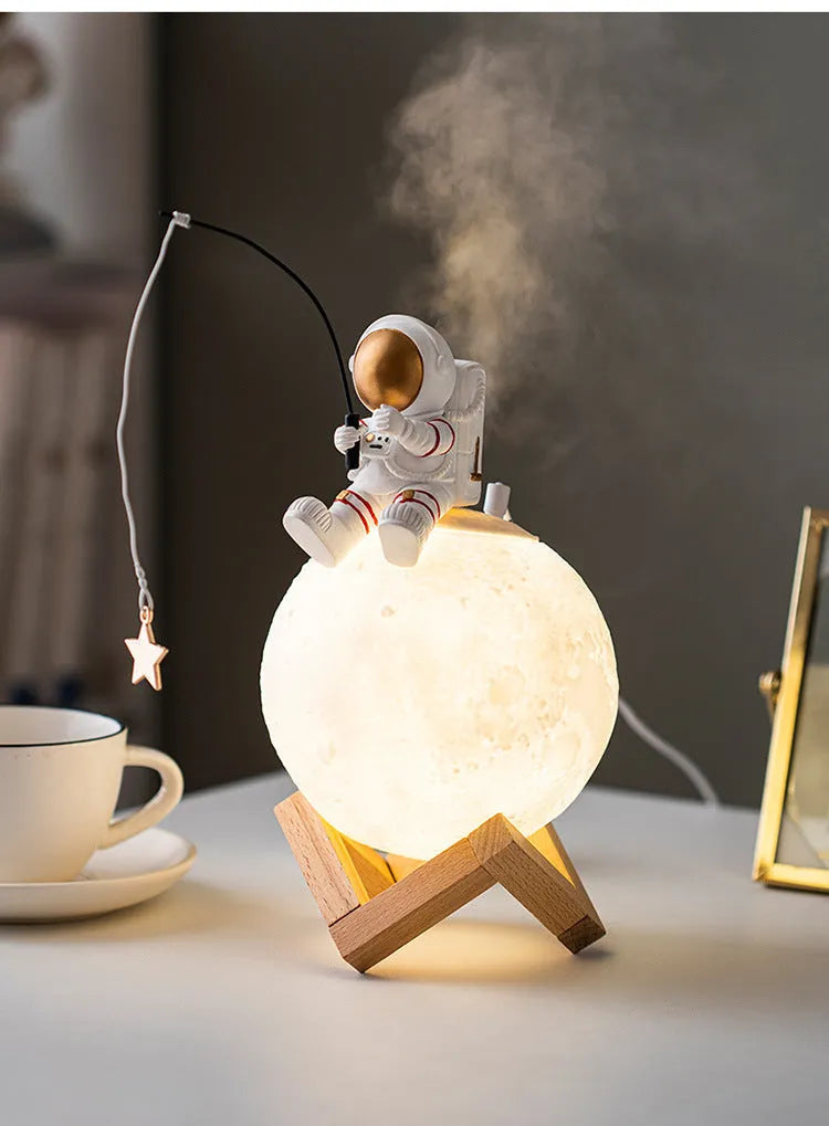 Gold resin astronaut figurine humidifier night light with wood base, 28 cm tall, on a desk