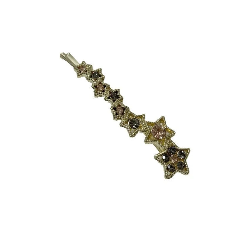 Gold-coloured alloy hair barrette with a side clip, rhinestones, a star, and a word decoration.