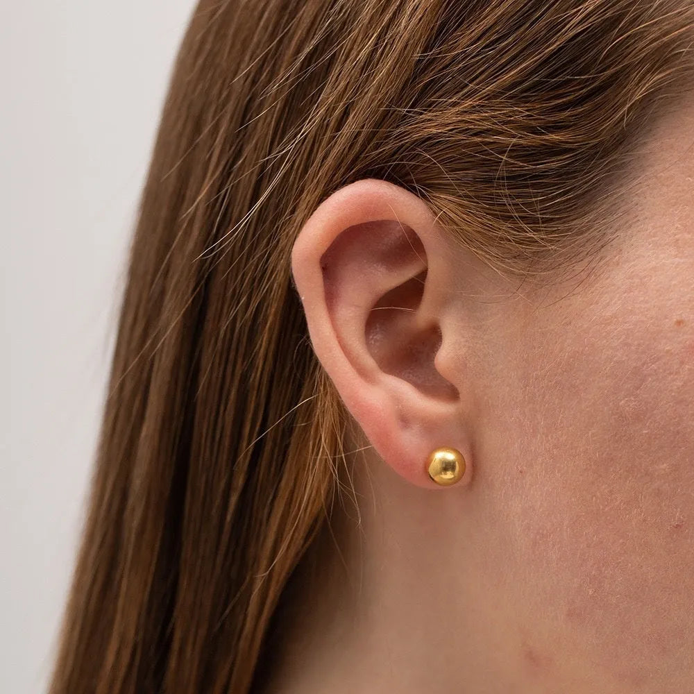 Stainless steel round ball stud earrings on a plain background, showing gold and silver tone options.