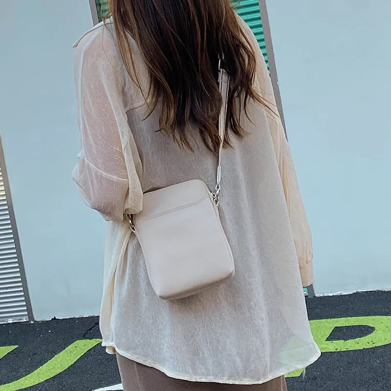 Simple solid colour PU leather crossbody phone bag for women shown in beige.