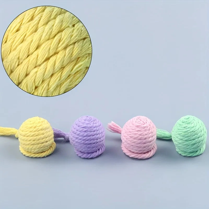 Green cat toy ball with attached rope on a wooden floor, shown next to a yellow 3cm size version.