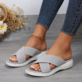 Black flat wedge peep-toe women's slippers with a cross-strap and thick rubber sole.