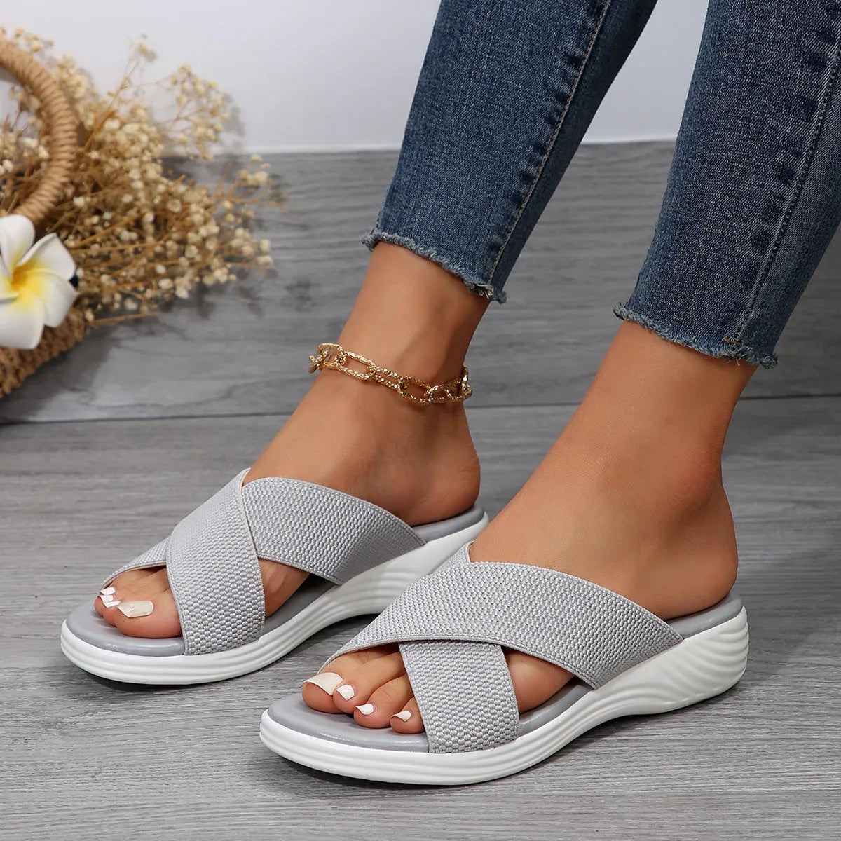 Black flat wedge peep-toe women's slippers with a cross-strap and thick rubber sole.