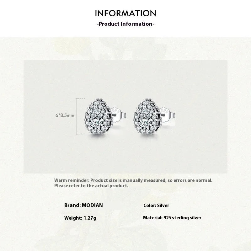 Close-up of a pair of women's silver water drop shaped stud earrings on a plain background.