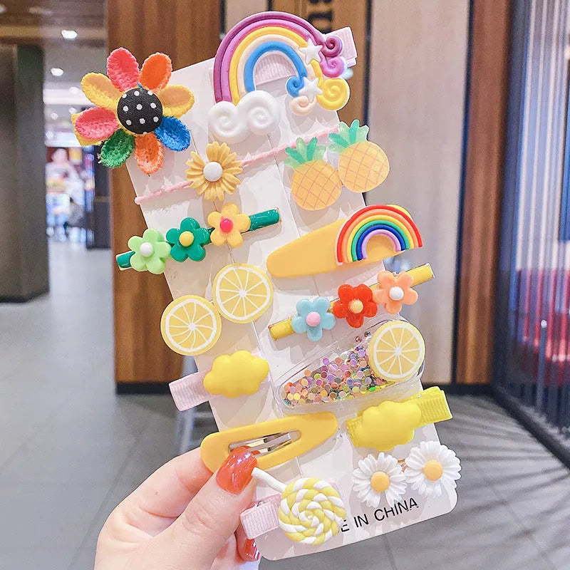 14-piece set of colourful toddler hair clips with candy, fruit, rainbow, and butterfly designs on a white background.