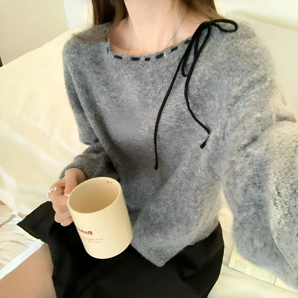 Grey loose-fitting women's knitwear pullover jumper on a hanger.
