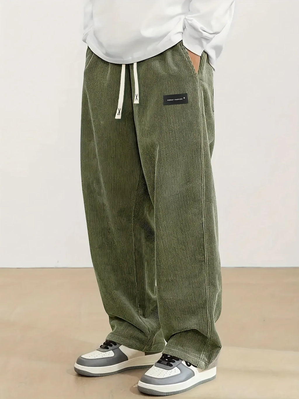 Men's corduroy straight-leg trousers in khaki with drawstring waist on a model, front view
