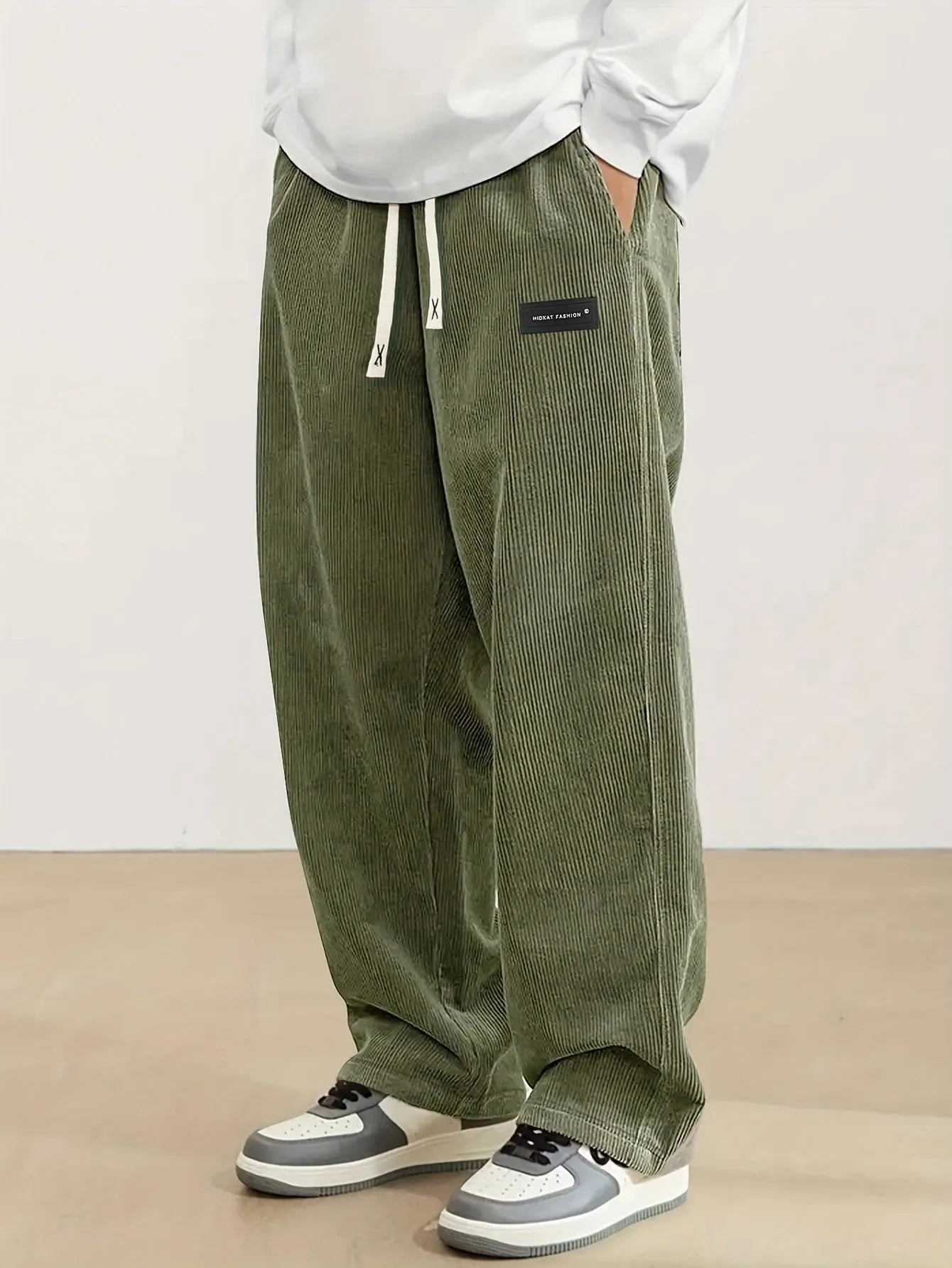 Men's corduroy straight-leg trousers in khaki with drawstring waist on a model, front view