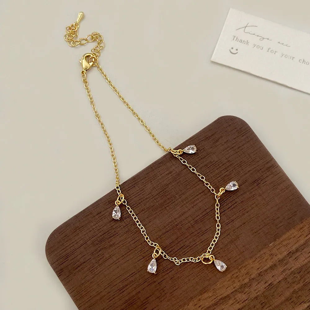 Zircon jewellery set with geometric necklace, matching earrings, and anklet featuring meteor shower design