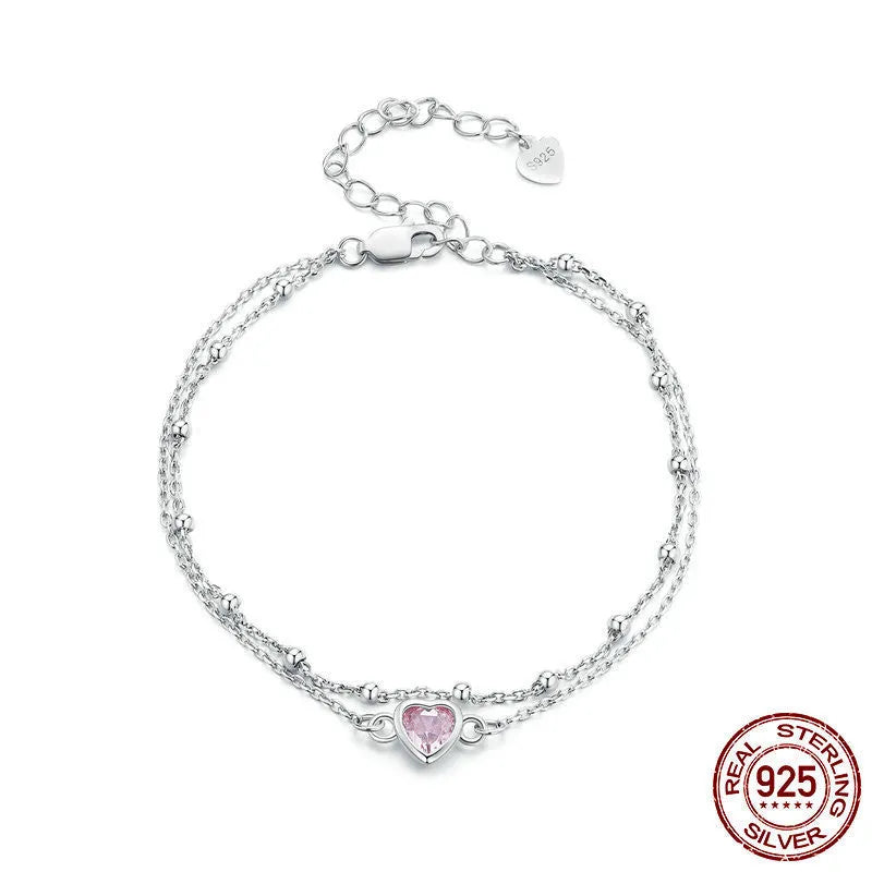 Women's sterling silver bracelet with a small heart-shaped charm on an adjustable chain.
