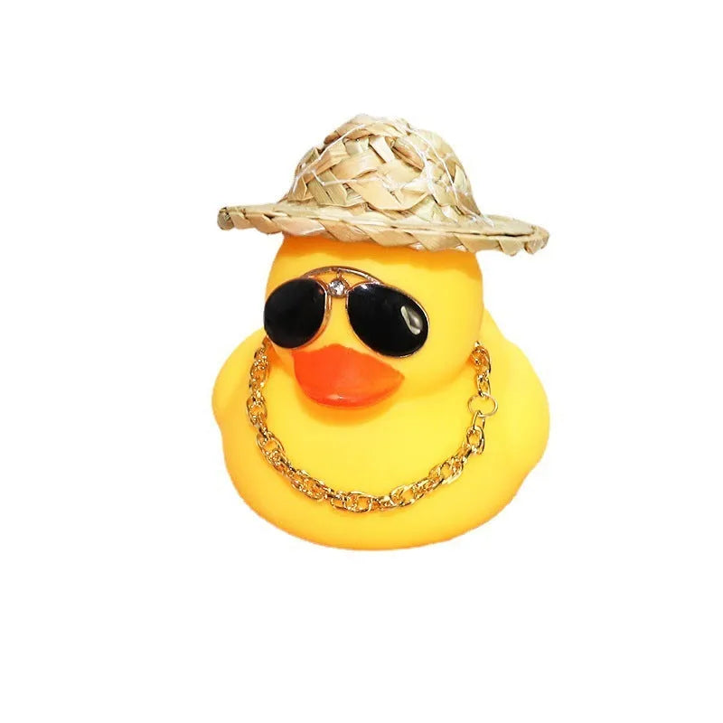 Matte yellow cartoon duck wearing a straw hat car ornament on a dashboard.