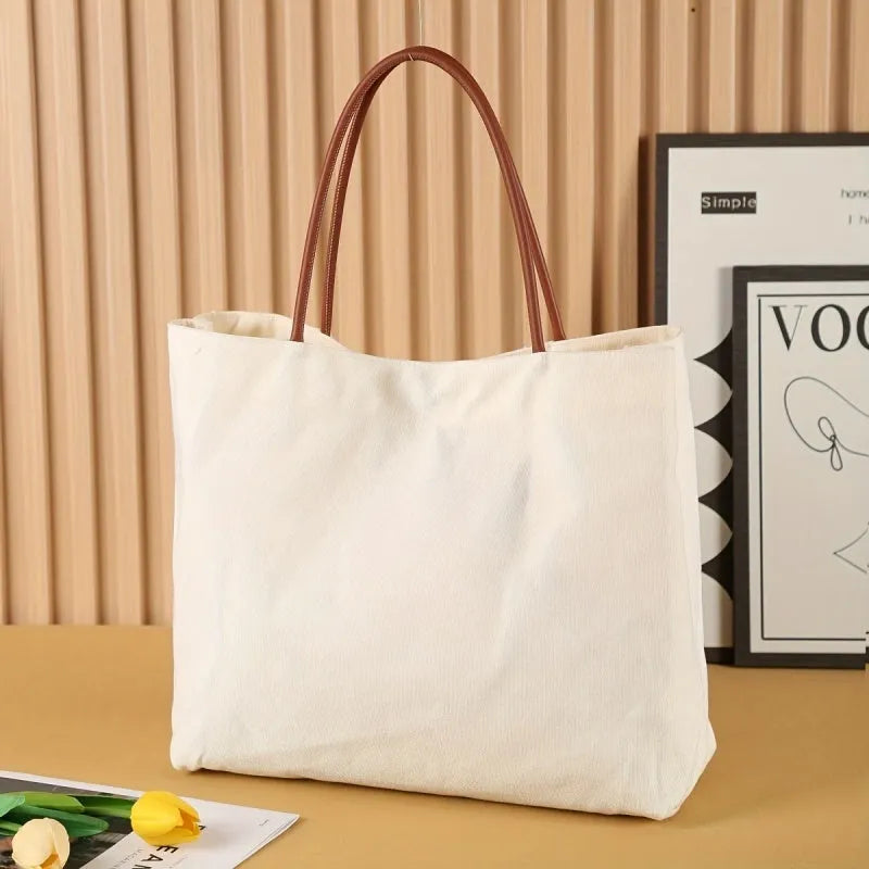 Beige white canvas tote bag with a front zip pocket and sturdy shoulder straps laid flat.