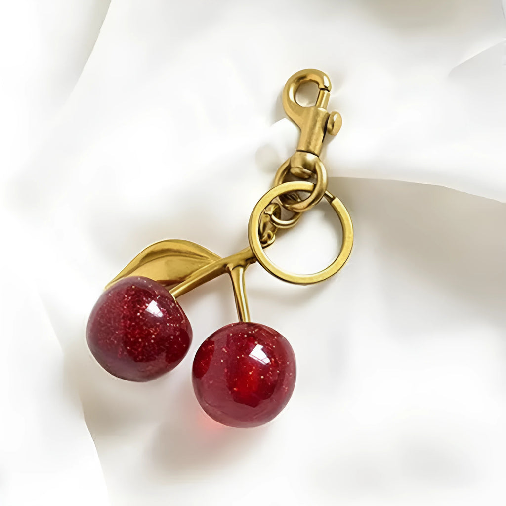 Close-up of a red zinc alloy keychain pendant shaped like a detailed three-dimensional cherry.