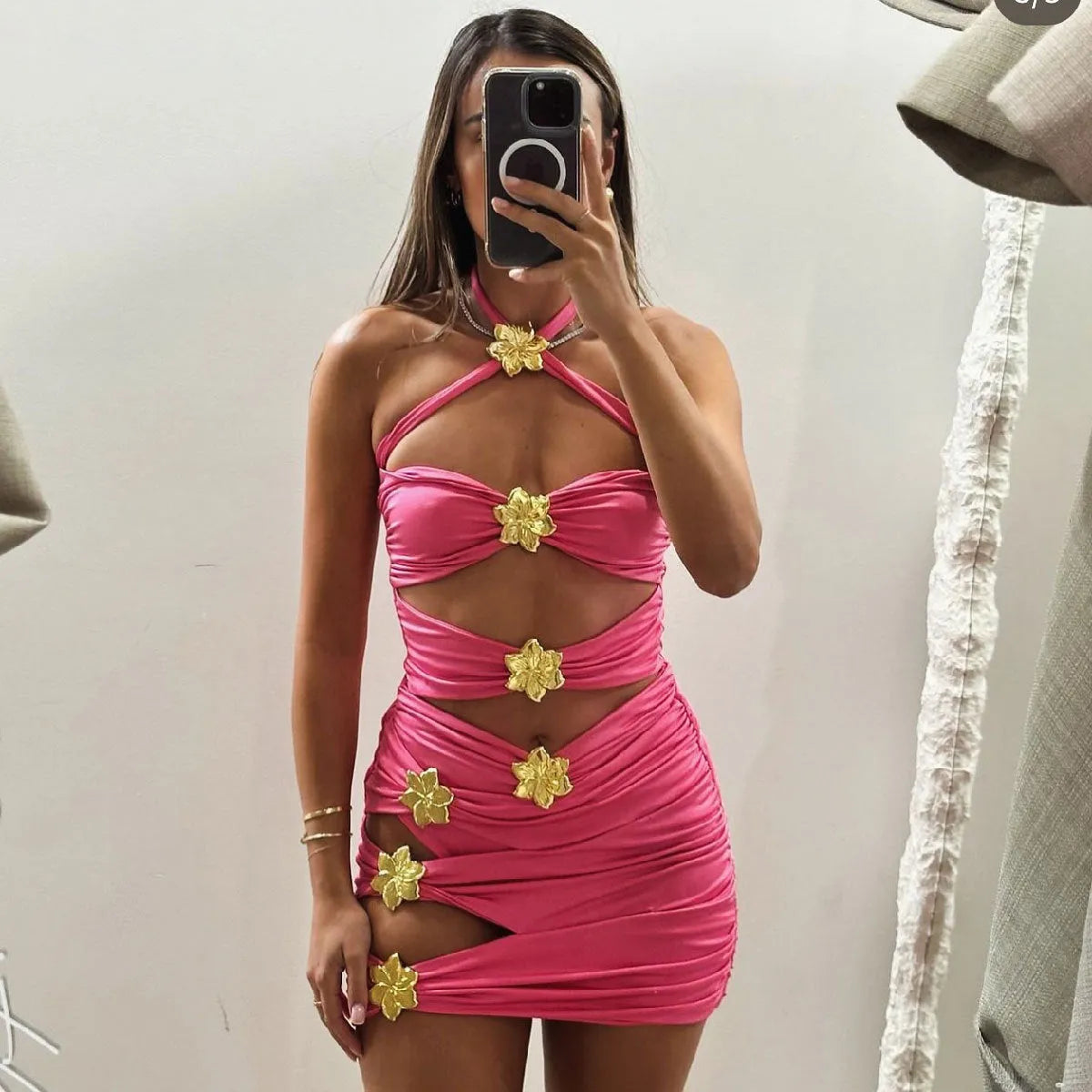 Adult woman wearing a solid colour one-piece swimsuit with a hollow-out tube top and a separate matching short skirt.