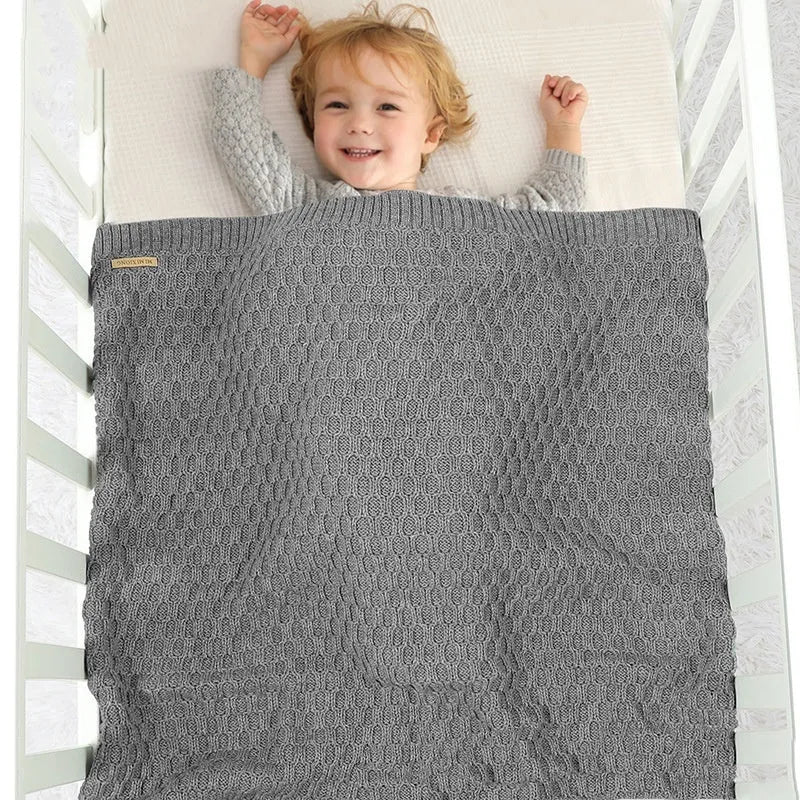 Solid colour infant hug blanket with textured three-dimensional lines, shown in a light colour option.